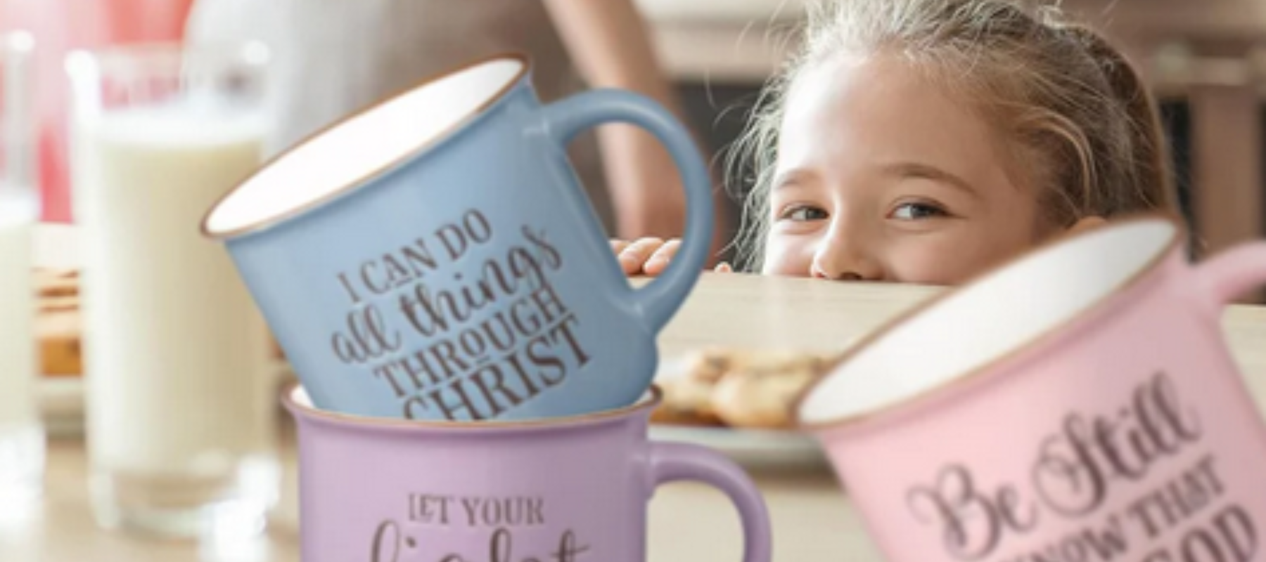Child peaking over table and 3 bible scripture mugs on the table