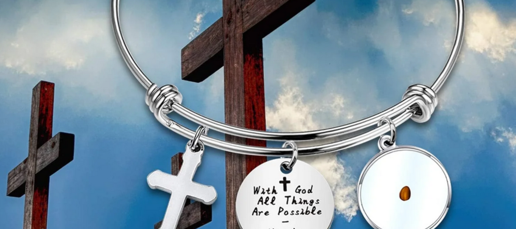 Blue sky background with three crosses, and bracelet upclose with three items on it.